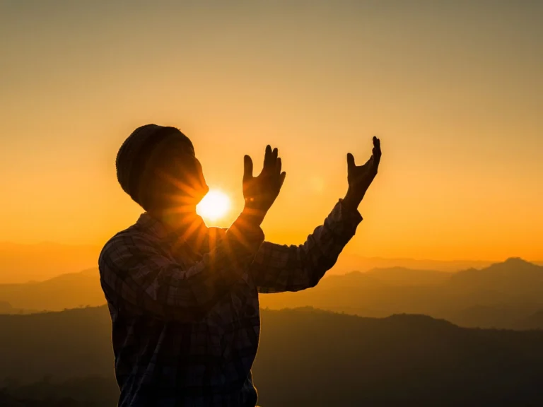 夕陽下張開雙手的人影