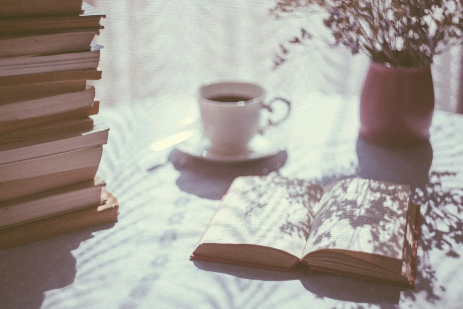 晨光灑在桌上的茶杯與攤開的書